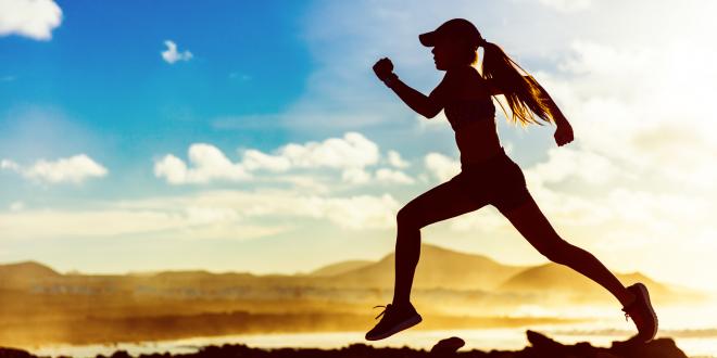 Silhouette of a female athlete runner running in sunset.