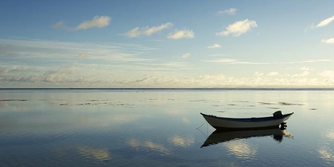 a small boat floating in still and empty waters