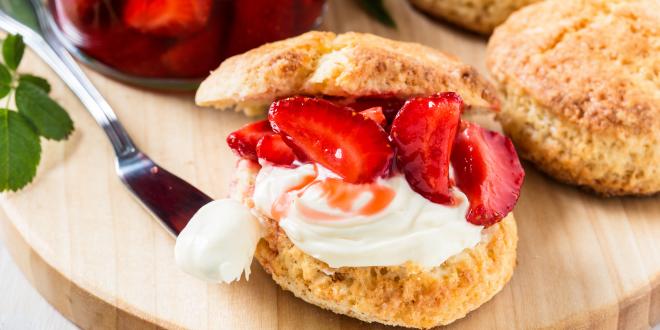 Shortcake biscuit cut open with strawberries and whipped cream in the middle.