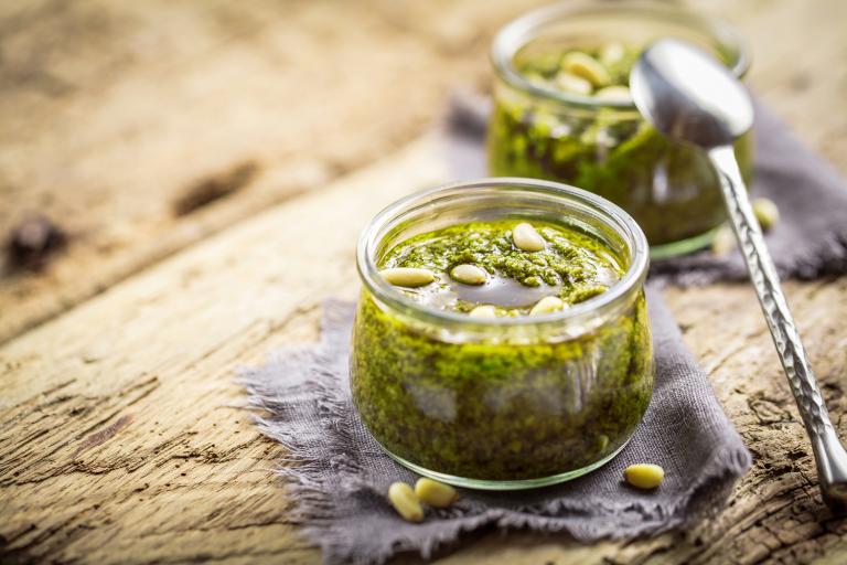 Tomatillo-Sunflower Salsa Verde in glass jars on a rustic wooden table.